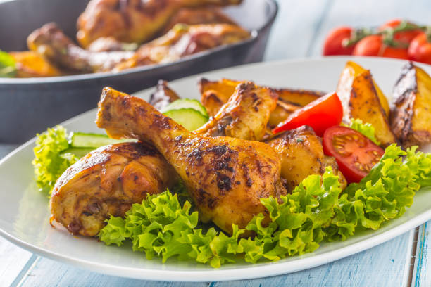 istock Roasted chicken legs with lettuce salad and tomatoes 1200862719
