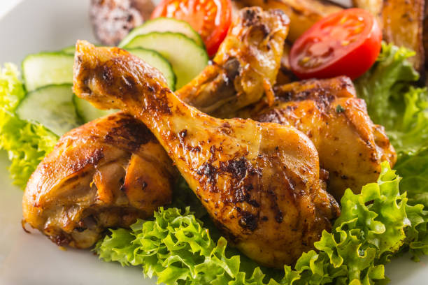 istock Roasted chicken legs with lettuce salad and tomatoes 1200862753