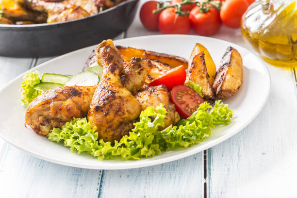 istock Roasted chicken legs with lettuce salad and tomatoes 1200862755