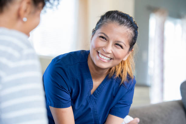 enfermera de salud sonriendo al paciente después del examen - scrub brush fotografías e imágenes de stock