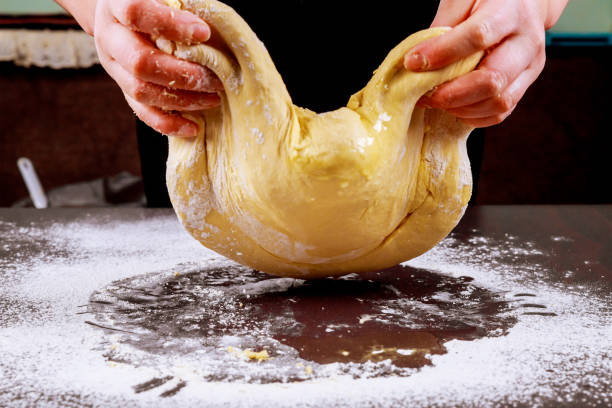 Woman kneading dough for making bread.