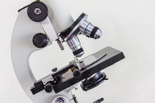 microscope with high magnification lens with black plate with white background