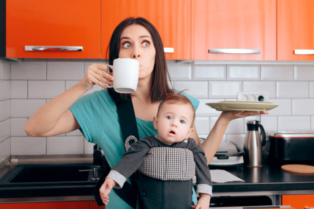 istock Busy Multitasking Mom with Baby, Coffee Mug and Dishes 1200869844