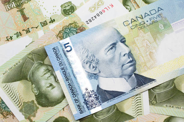 istock A Canadian five dollar bill on a background of dollar bills 1200870102