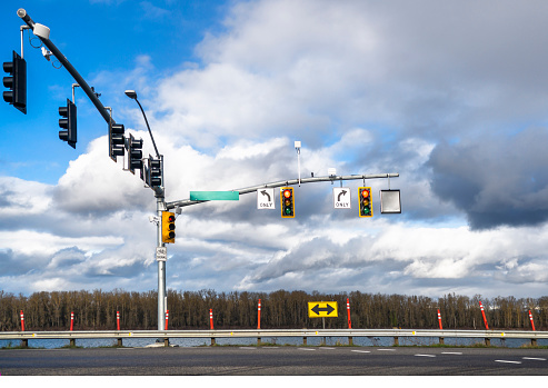 Traffic light pole with many traffic lights for different directions of traffic at the intersection with an arrow navigating the permitted direction of movement
