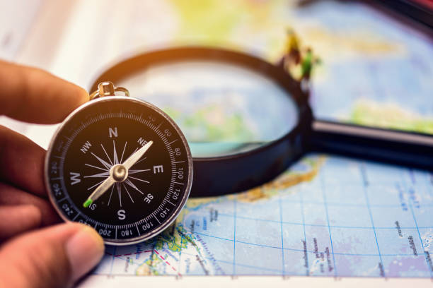 istock A compass that is used to travel with a magnifying glass and map that has a blurry background. 1200878765