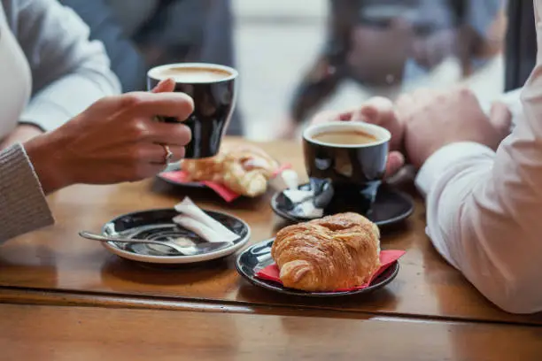 Photo of croissants and coffee, french breakfast in cafe for couple