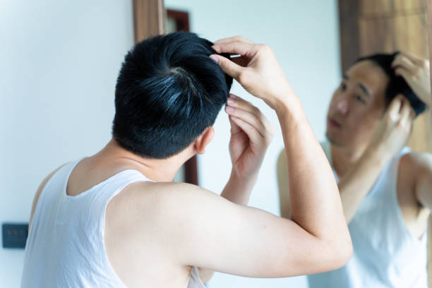 istock Young Asian guy styling hair in bathroom 1200881888