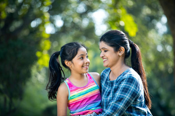istock Mother embracing daughter at park 1200883842