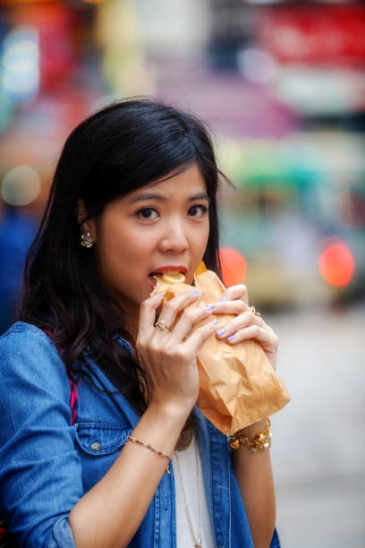 istock Young Asian woman eating Egg Waffle 1200885250