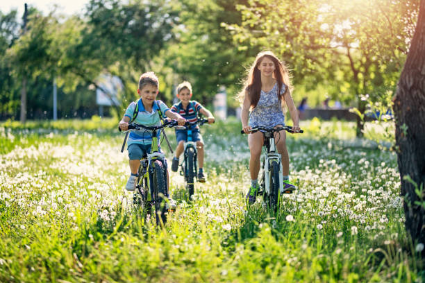 istock Children riding bicycles in dandelion field 1200888493