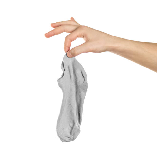 istock Hand holds dirty smelly sock. Close up. Isolated on a white background 1200889937
