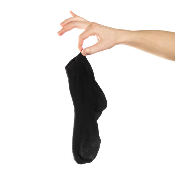 istock Hand holds dirty smelly sock. Close up. Isolated on a white background 1200889939