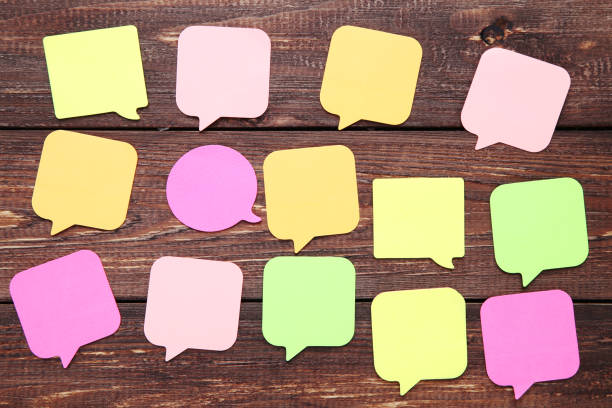 istock Paper speech bubbles on brown wooden table 1200892217