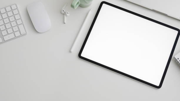istock Top view of workspace with digital tablet, copy space, computer, laptop and office supplies on white desk 1200894446