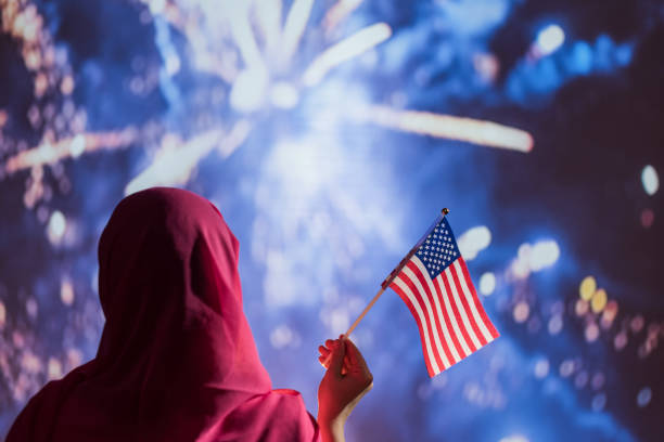 밤에 불꽃 놀이 동안 미국 국기를 들고 스카프에 무슬림 여성. - eastern european flash 뉴스 사진 이미지