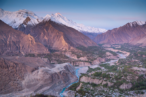 view of the Pakistani Karakorum mountains, K2 and Nanga Parbat. Clouds partly hide mountains, valleys and glaciers.