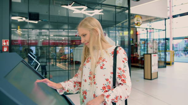 istock Young female looking for right direction on navigation board in modern mall 1200895626