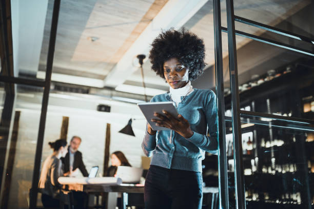 istock Young African-American woman architect using a digital tablet in front of the architecture studio 1200897338