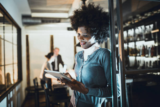 istock Young African-American woman architect using a digital tablet in front of the architecture studio 1200897342