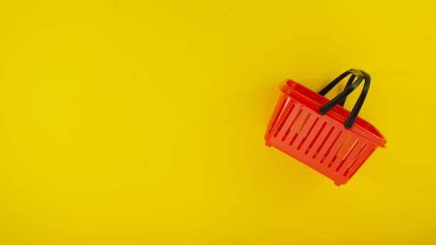 istock Red shopping basket on yellow background minimalist consumer concept 1200902191