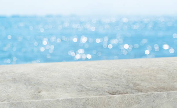 istock summer background.Empty diagonal grunge concrete table with blur sea and sky boekh background,banner mockup template for display of product 1200905491