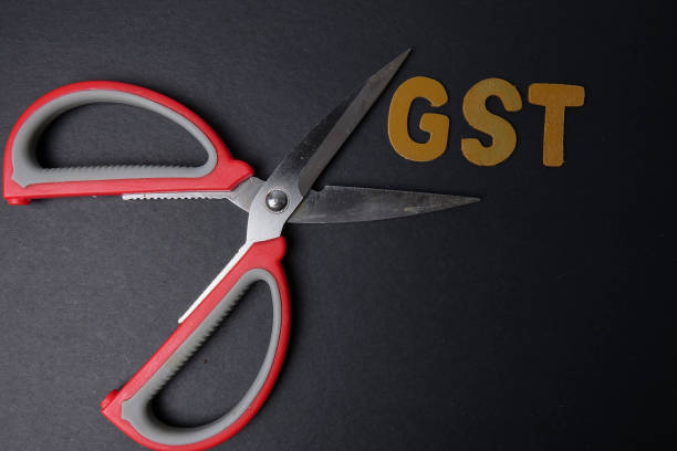 istock Scissors and word of GST on black background 1200905519