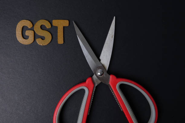 istock Scissors and word of GST on black background 1200905547