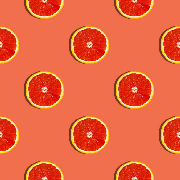 istock Fresh red orange or grapefruit on a peach color background. Pattern seamless tropical fruit photo. 1200905584