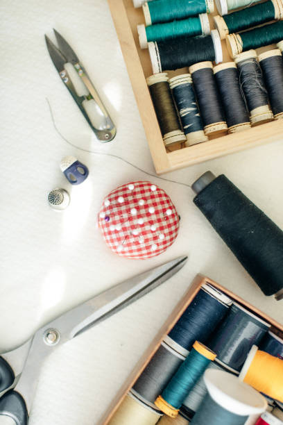 istock a seamstress sews a button on a red coat. 1200905988