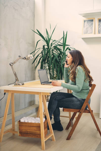 istock Young attractive female having phone call in modern office. 1200908437