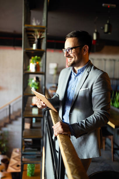 istock Happy businessman dressed in suit in modern office using tablet 1200911212
