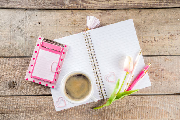 istock Cup of coffee with flowers and sketchbook 1200912427