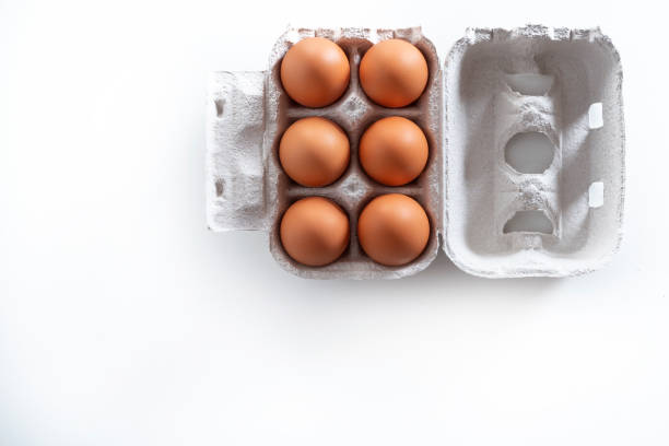 Six Brown eggs on cardboard box gray carton isolated on white background