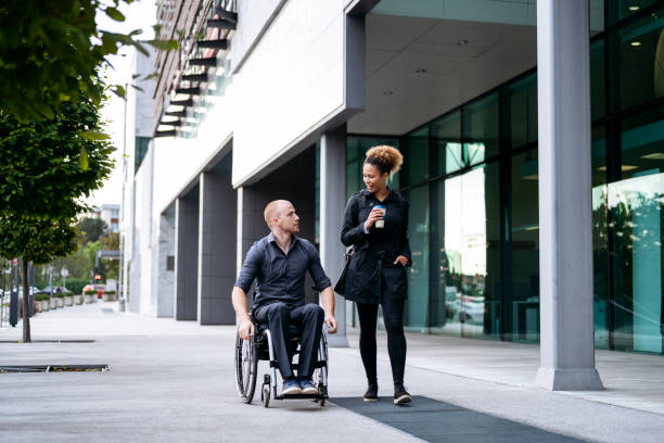 jóvenes compañeros de negocios masculinos y femeninos que llegan por trabajo - business two people talking building exterior fotografías e imágenes de stock