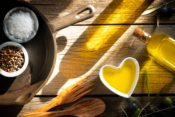 istock Olive oil bottle and cast iron pan on rustic table 1200912826