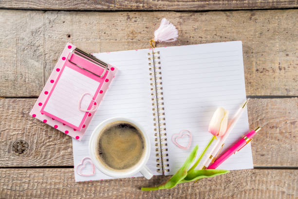 istock Cup of coffee with flowers and sketchbook 1200913931