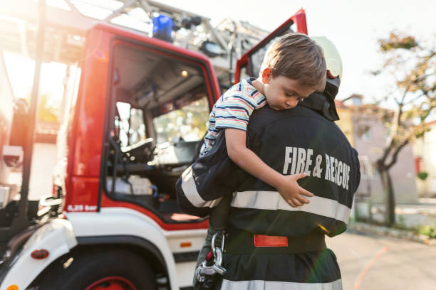 istock Firefighter carrying stressed little boy 1200914255