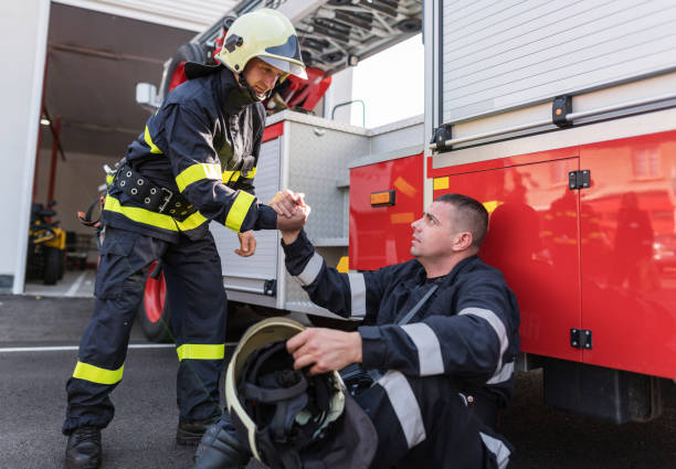 istock Firefighter giving a friendly hand to a colleague 1200914265