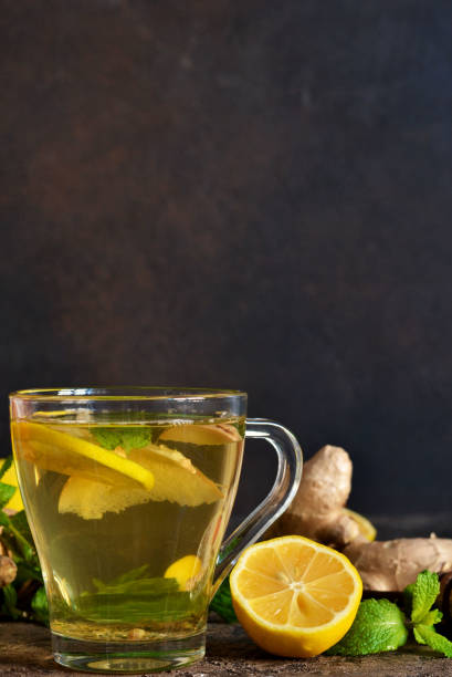 istock Hot tea with ginger, mint and lemon on a brown concrete background. Horizontal focus. 1200916601