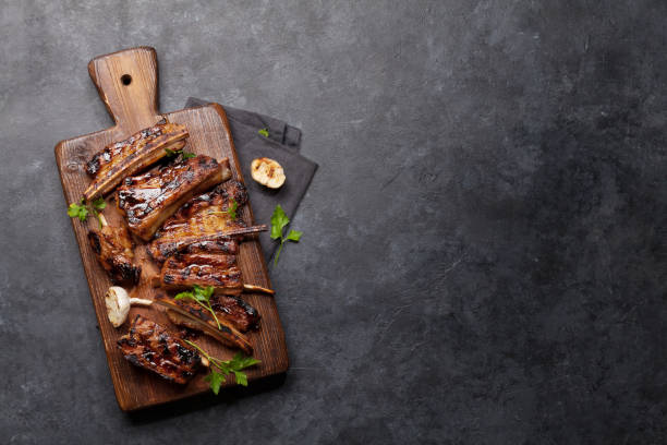 Barbecue beef ribs with bbq sauce sliced Barbecue beef ribs with bbq sauce sliced on a wooden board. Top view flat lay with copy space marinated photos stock pictures, royalty-free photos & images