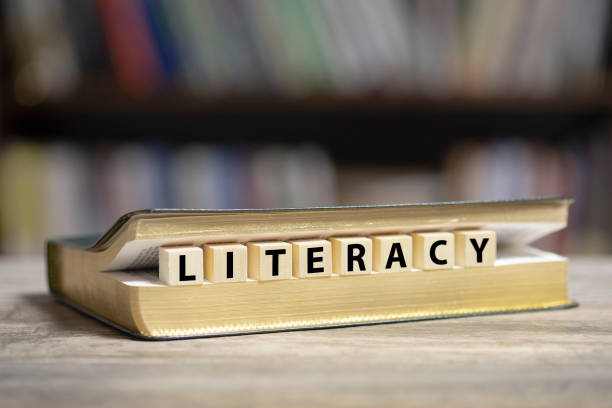 Book on desk with Literacy word Book on desk with Literacy word written on wooden cubes literacy photos stock pictures, royalty-free photos & images