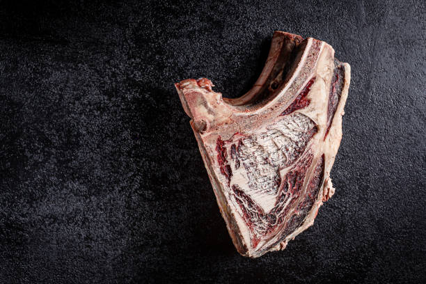 modern kitchen. dry aged beef, veal meat with red pepper and rosemary lies on a black background. board background image, copy space text, top view - scotch steak imagens e fotografias de stock