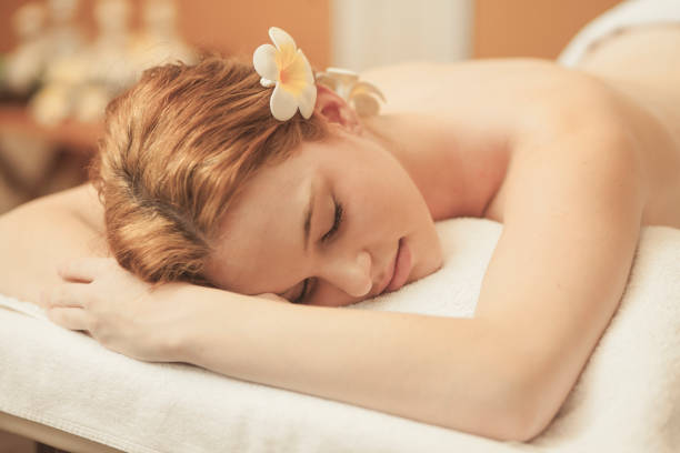 Spa room interior with defocused book shelf background massage bed, candles, spa items. Wellness and health. 3d rendering