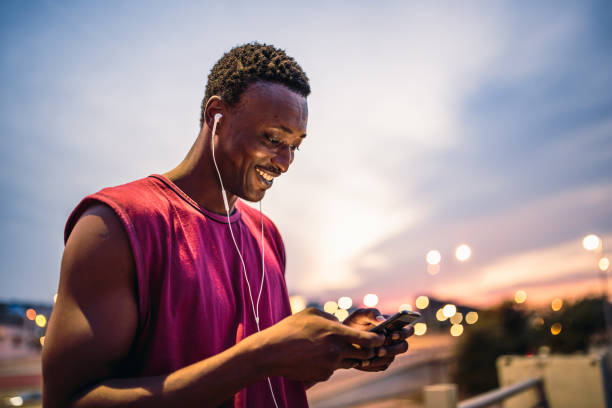 istock Young African american athlete texting after jogging 1200923041