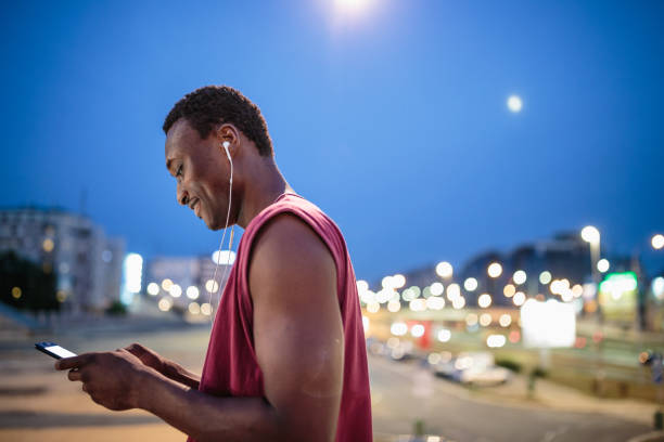 istock Young African american athlete texting after jogging 1200923045