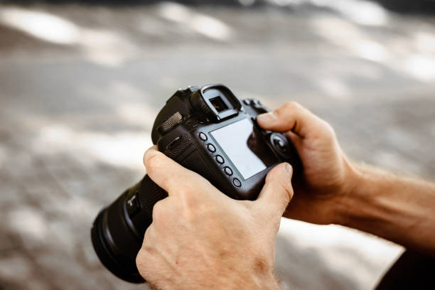 istock Male hands holding photo camera, professional camera in hand 1200924764