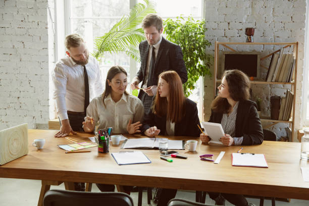istock Group of young business professionals having a meeting, creative office 1200925574