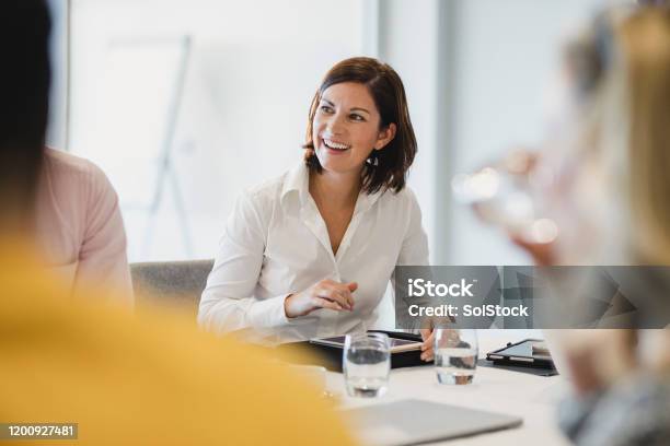 Cheerful Mid Adult Woman Smiling At Business Meeting Stock Photo - Download Image Now