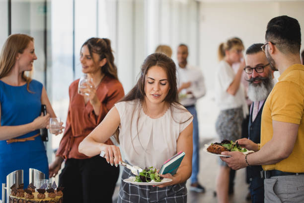 istock Young woman serving herself at corporate buffet 1200927712